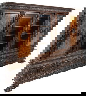 Monumental Renaissance Revival Bookcase: Monumental Renaissance Revival oak bookcase, with crown resting on middle section that features pair of glass library doors flanked my pair of inlaid wooden doors, supported on large base that has