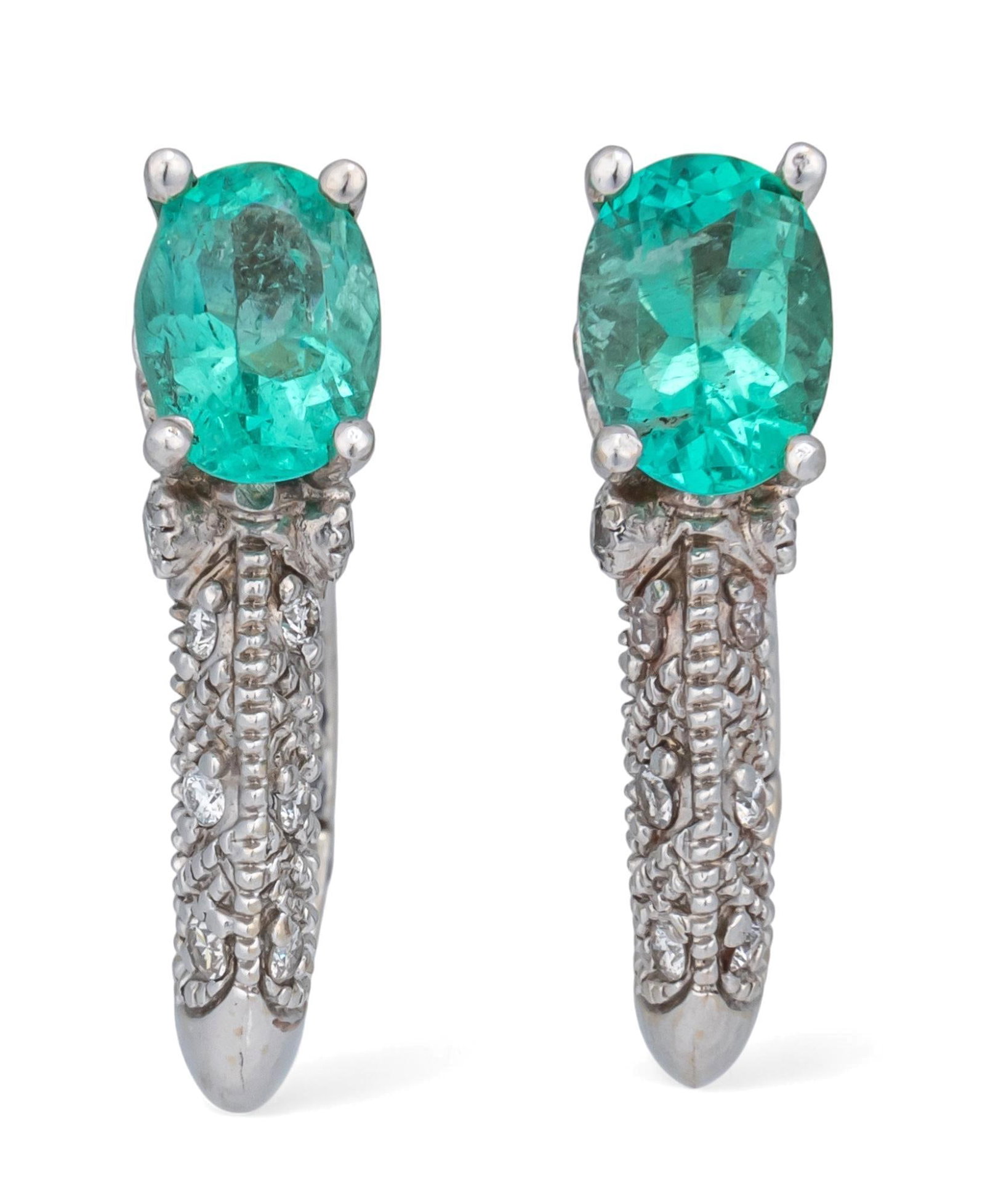 14K White Gold Emerald and Diamond Earrings: 14K white gold emerald and diamond earrings featuring oval cut emeralds (approx. 8.44 x 6.77 x 3.90 mm) with small inlaid diamonds along hoop, marked "Declo 14K " Length: 0.75 in. Total weight