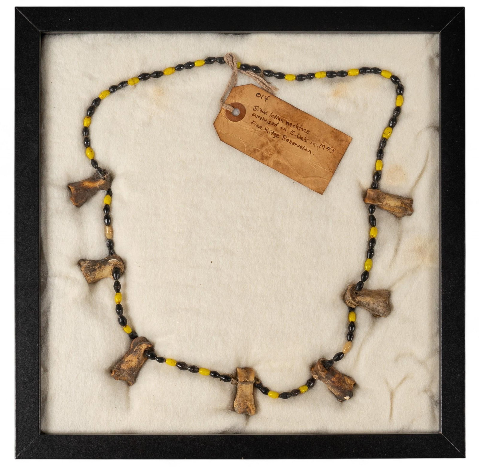 Sioux Native American Bone Beaded Necklace: Sioux Native American bone beaded necklace featuring yellow and lack beads with bone accents, with authenticity note, in shadow box