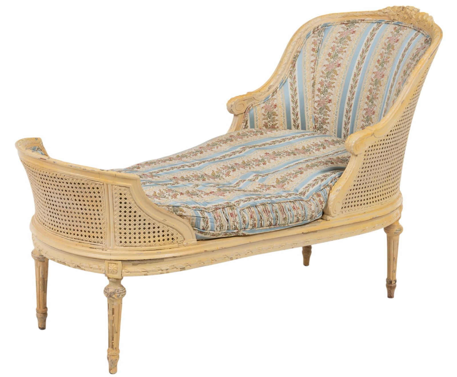 Louis XVI Style Chaise Lounge: Louis XVI style chaise lounge featuring carved wooden frame with canework, and removable cushion with embroidered floral and stripe pattered fabric, supported on fluted legs, with creamy yellow paint