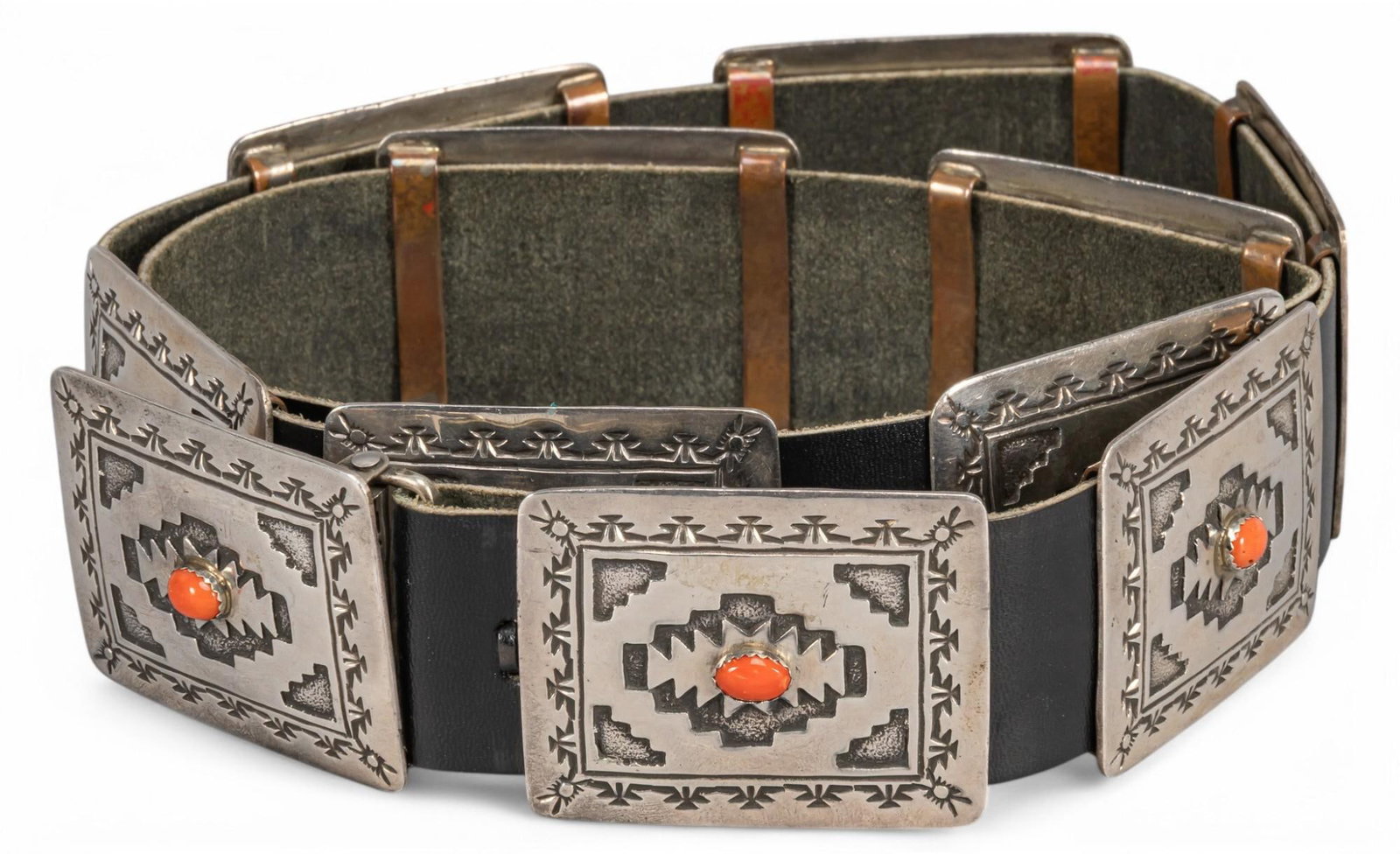 Sterling Silver Coral Navajo Concho Belt: Sterling silver coral Navajo concho belt featuring ten conchos with engraved details and inlaid coral, marked "Sterling EK" Length: 42 in. Total weight: 15.69 ozt Provenance: Property from the