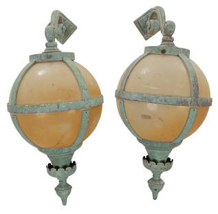 Pair of Large Outdoor Globe Sconces: Pair of large vintage outdoor globe sconces, glass orb shades in iron cages, with scrolled arm, and green paint remnant height 36 in. x width 16 in. x depth 16 in. / each Provenance: Property