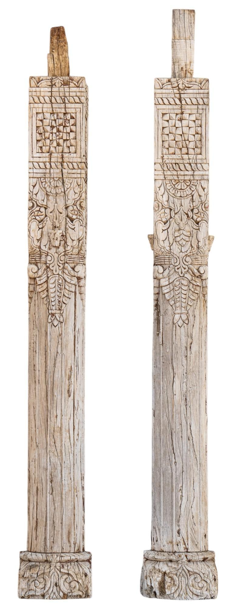 Pair of Carved Wooden Architectural Pillars: Pair of rustic wooden architectural pillars, each with carved floral and scroll motifs, supported on pedestal bases, with paint remnants height 78 in. x width 7 in. x depth 7 in. / largest Provenance: