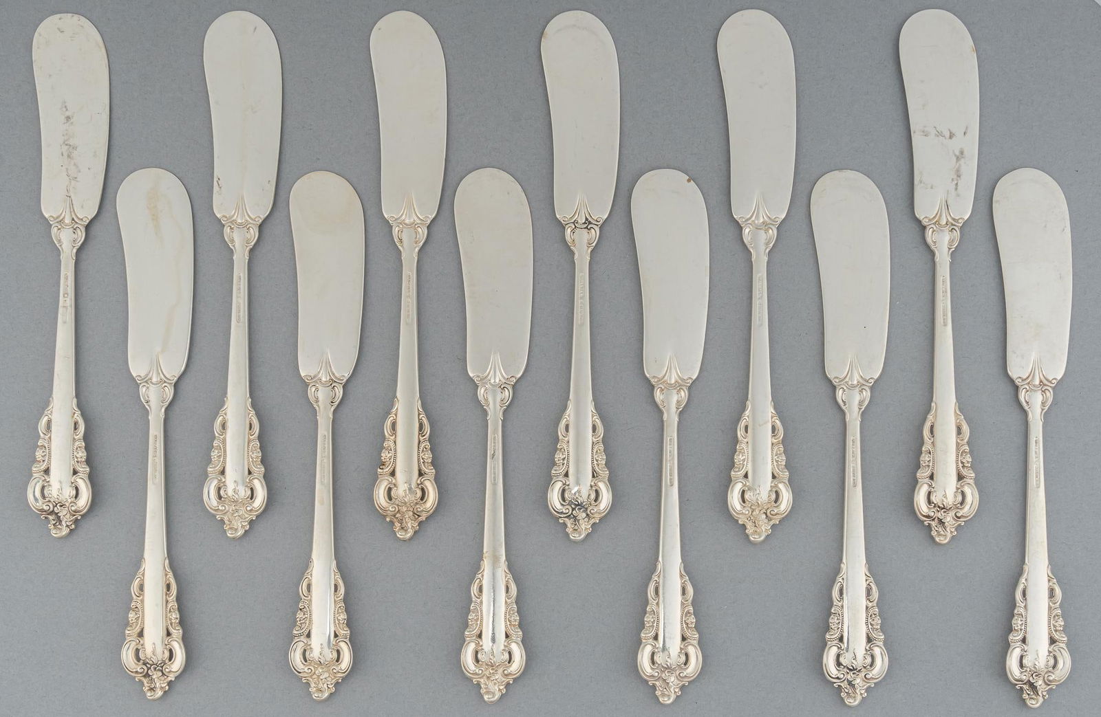 (12) "Grande Baroque" By Wallace Silversmiths Sterling Silver Butter Knives: Twelve "Grand Baroque" by Wallace Silversmiths sterling silver butter knives, marked "Wallace Sterling" Total weight: 12.8 ozt