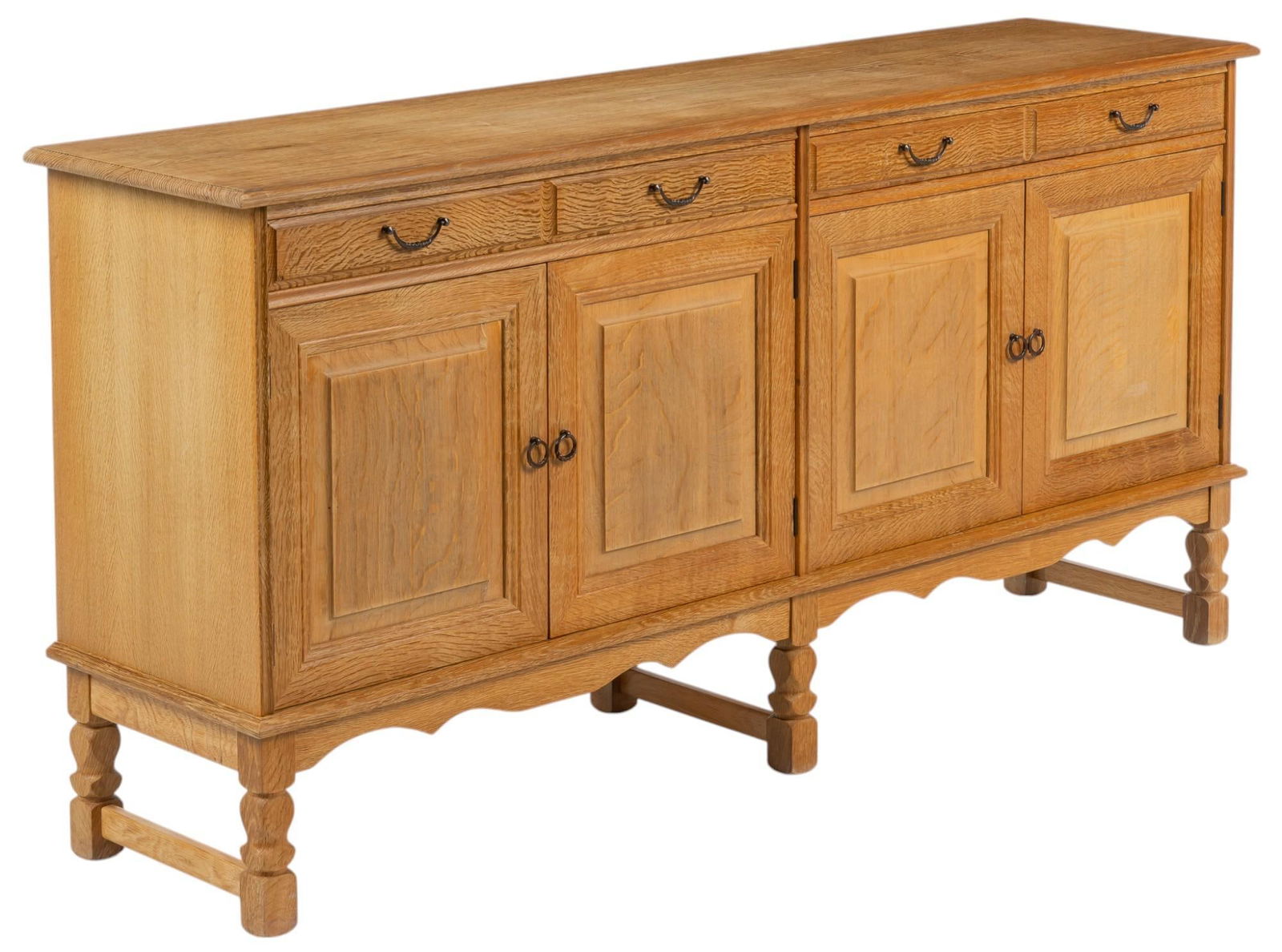 Henning Kjaernulf (DNK) Oak Mid-Century Credenza: Henning Kjaernulf (Denmark) mid-century oak credenza with four drawers with metal ring pulls, and two pairs of cabinet doors that open to interior with single shelf, with serpentine apron, carved on b