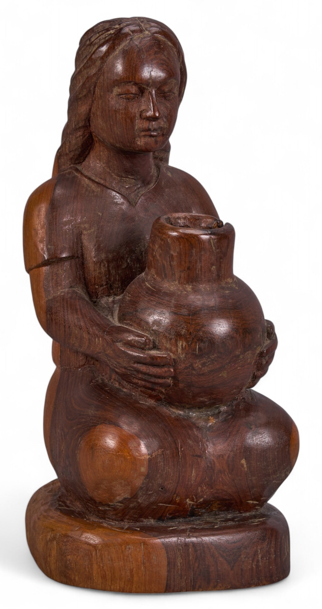 Carved Wood Sculpture of Woman with Vessel: Carved wooden figure of a woman holding a vessel, mounted on a circular base height 16 in. x width 7.5 in. x depth 8.5 in. Provenance: From the home of a San Antonio, Texas interior designer