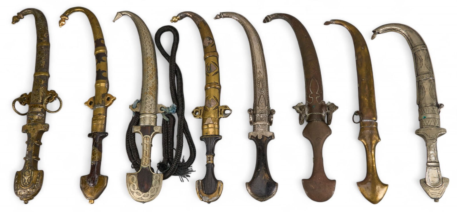 Collection of Eight Jambiya Daggers: Collection of eight Jambiya daggers with ornate metal handles and sheaths length 17 in. x width 3.25 in. x depth 1 in. / largest Provenance: Property from the historic Olmos Park estate of noted San A