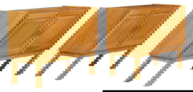 Pair of Henning Kjaernulf (DNK) Mid-Century Small Credenzas: Pair of Henning Kjaernulf (DNK) mid-century small oak credenzas featuring two hinged doors opening to interior storage space with two shelves, carved details on doors, metal pulls, on carved block leg