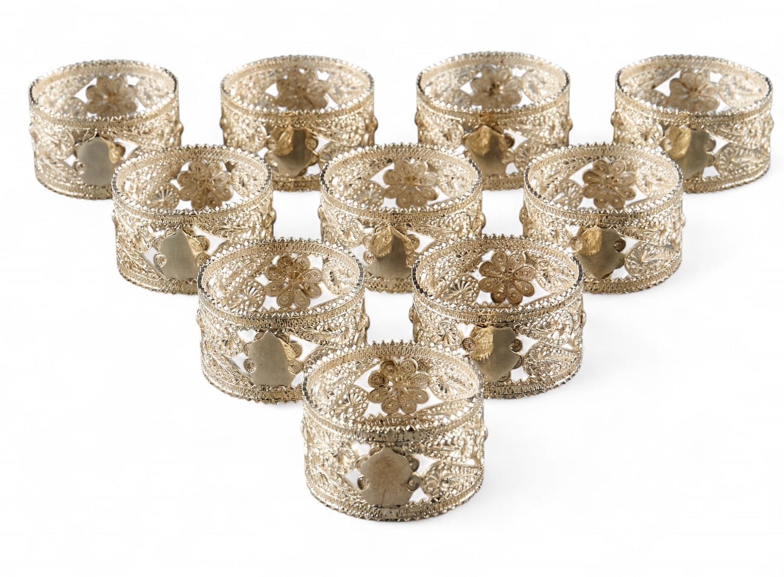 (9) Sterling Silver Filigree Napkin Rings: Set of nine sterling silver filagree napkin rings Total weight: 7.45 ozt Provenance: Property from the collection of a prominent San