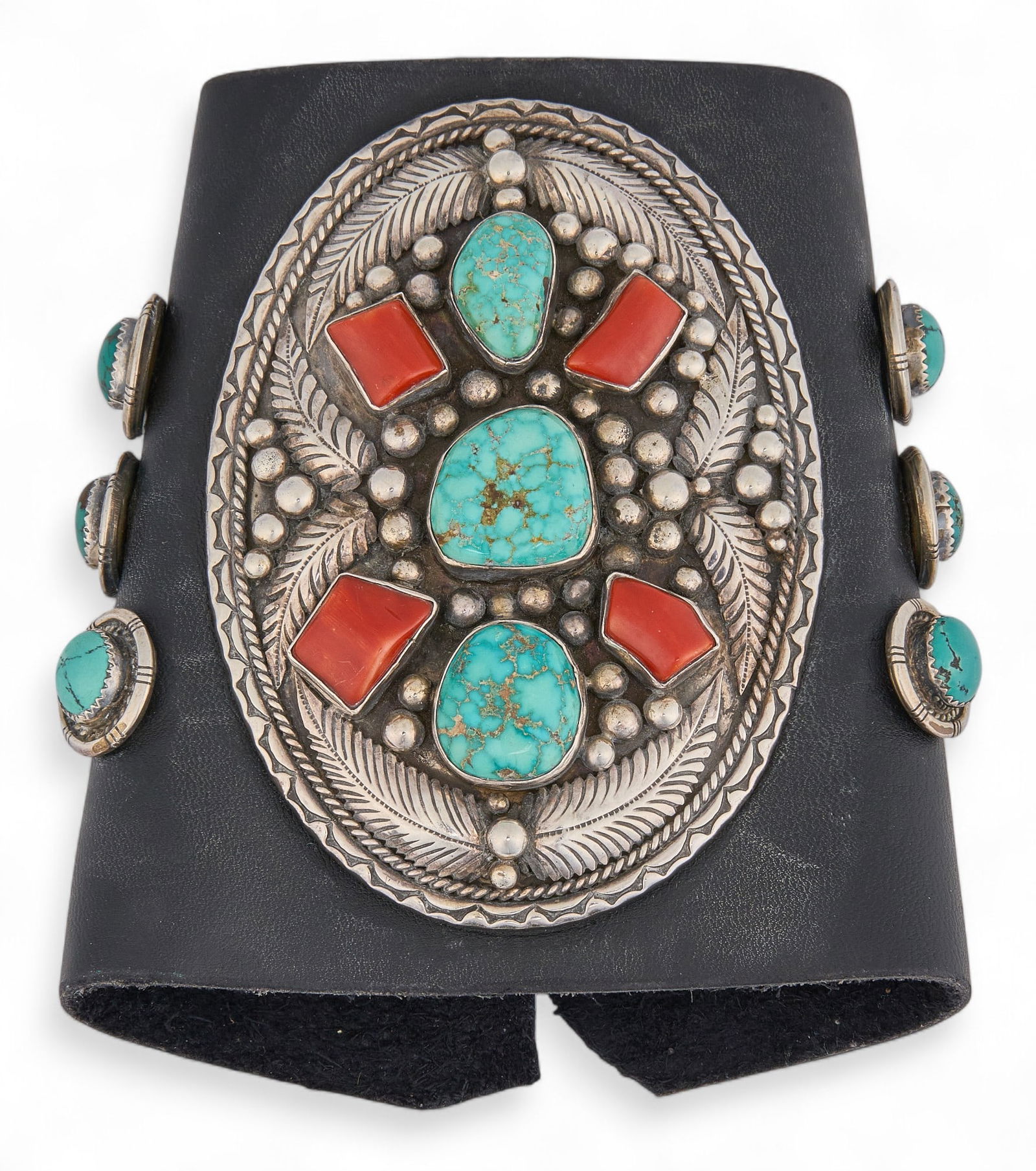 Sterling Silver, Turquoise & Coral Ketoh Cuff: A Ketoh (Navajo bow gaurd) leather cuff featuring a sterling silver plate inlaid with turquoise and coral stones, and buckle closure totaly weight: 4.71 ozt Provenance: Property from a home in San Ant