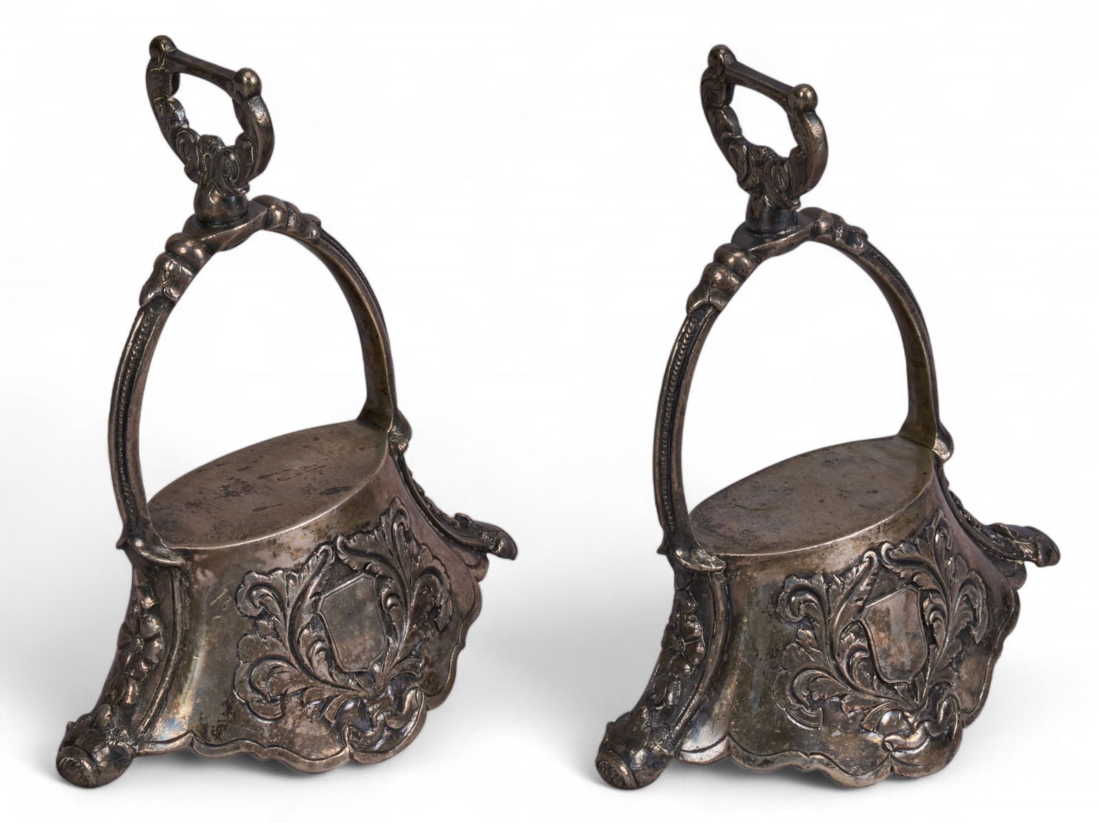 Antique Uruguayan Nickel Silver Bell Stirrups: Pair of antique Uruguayan nickel silver bell-type stirrups, with ornate repousse design, circa 19th century height 8.5 in. x width 6.75 in. x depth 3.25 in. / each Provenance: Property from a ho