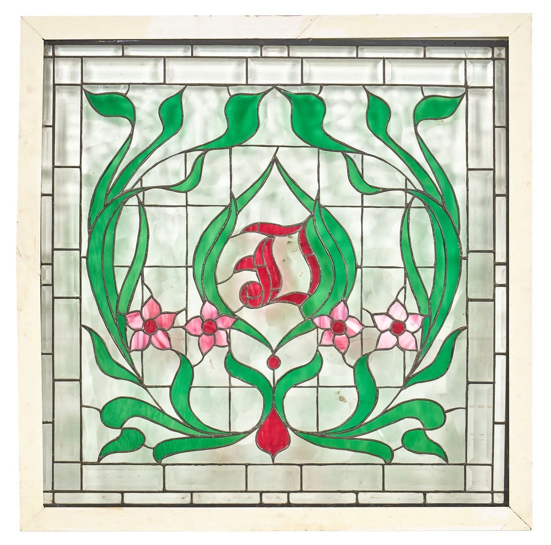 Floral Stained Glass Window Panel: Stained glass window panel with a floral design with green leaves, pink flowers, and a central red initial, set in a white wooden frame height 38 in. x width 38 in. x depth 1 in. Provenance: Prop