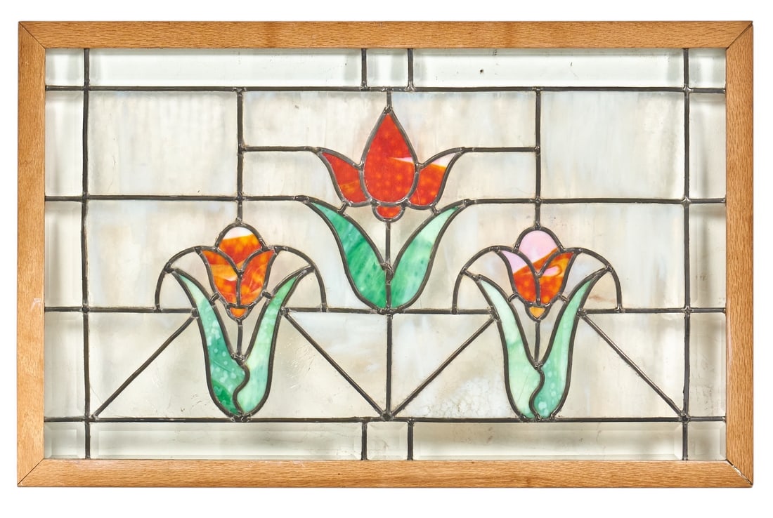 Floral Stained Glass Window Panel: Stained glass window panel with a red, orange, and green tulip motif against a clear textured glass background, in wooden frame height 21.5 in. x width 34 in. x depth 1 in. Provenance: Property f