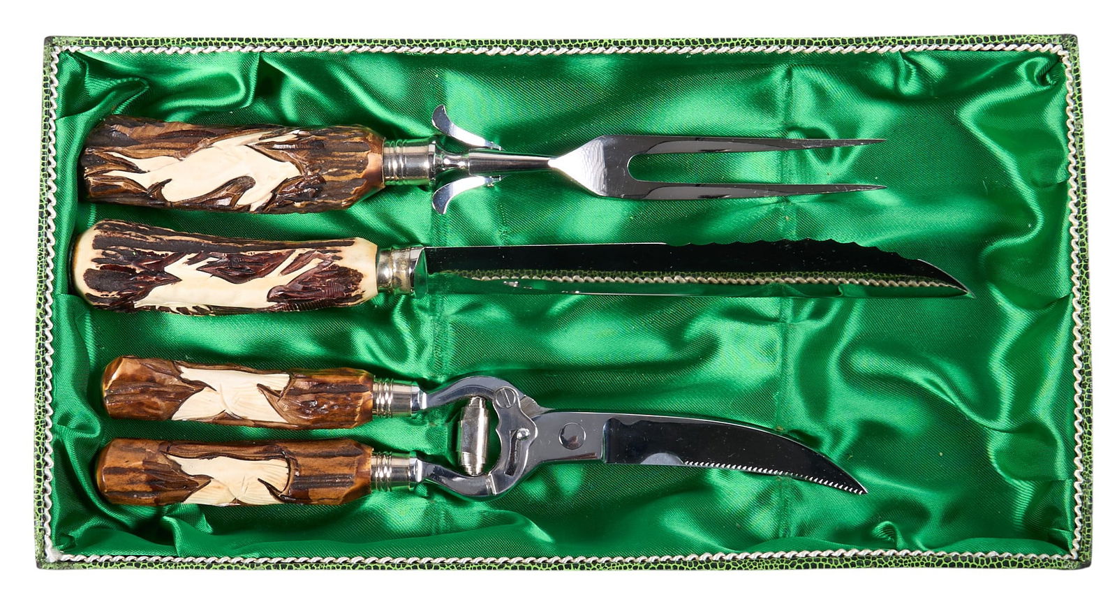 Stag Handled Carving Set: Three-piece carving set with stag horn handles and carved game bird motifs, to include a carving fork, knife, and poultry shearslength 12 in. x width 2 in. / knifeProvenance: Property from