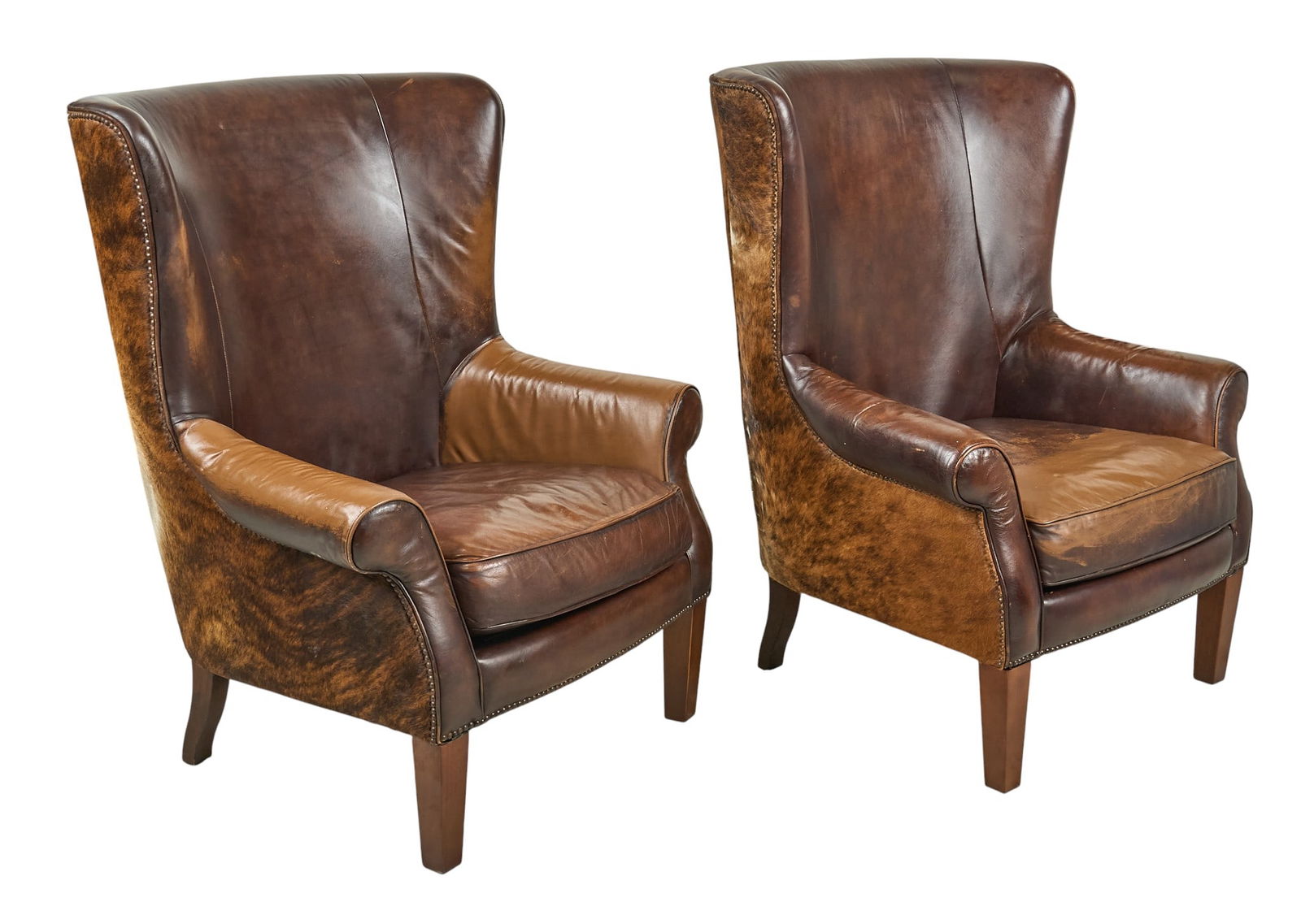 Pair of Hair on Hide Chairs: Pair of ranch style chairs with brown leather, and hair on cowhide upholstery, supported on block legs height 50 in. x width 39 in. x depth 37 in. / each Provenance: Property from a home in San Antoni