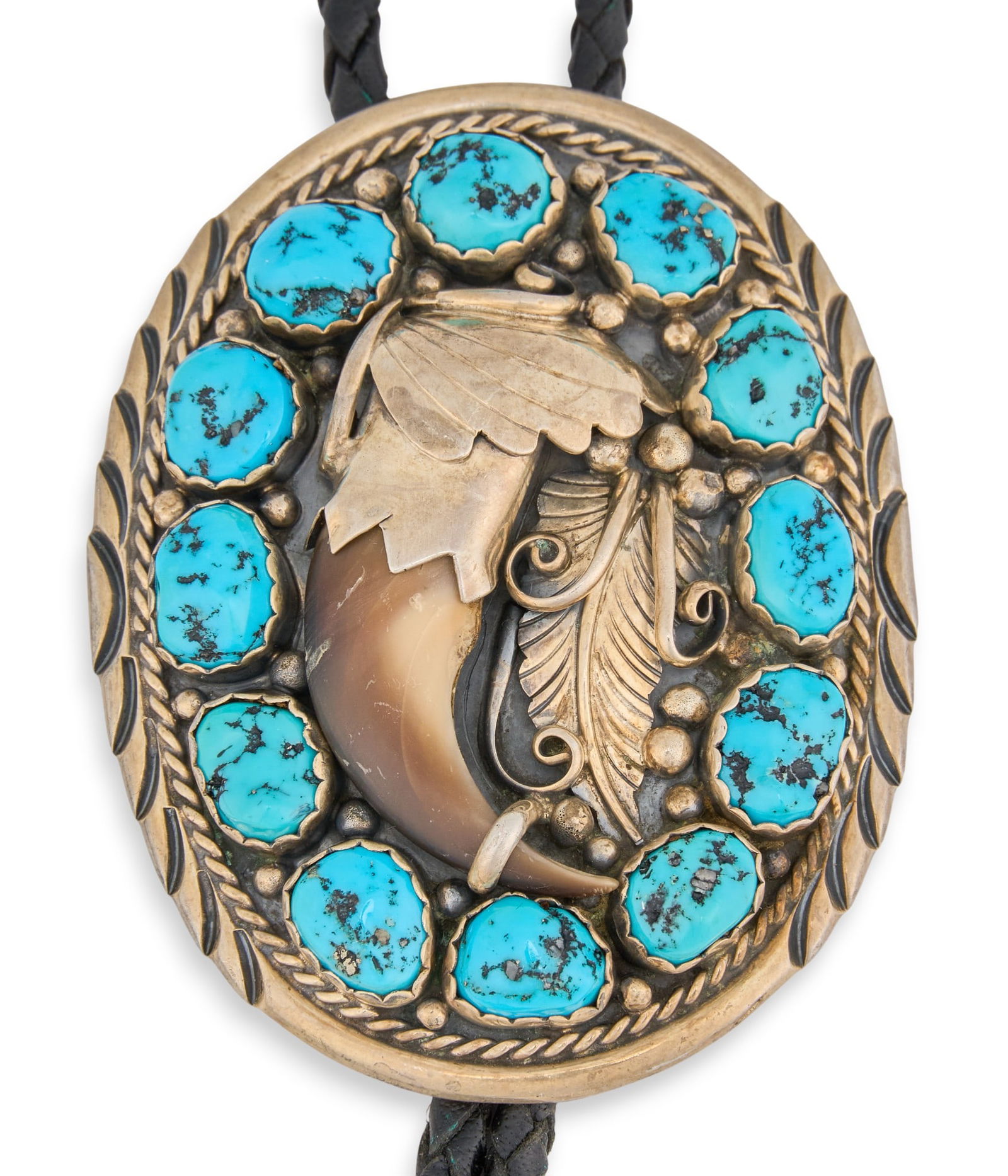 Sterling Silver Turquoise & Claw Bolo Tie: Sterling silver bolo tie featuring inlaid turquoise stones flanking bear claw detail, with twisted rope and feather details, on braided black leather cord Length: 38 in.Total weight: 2.375 ozt