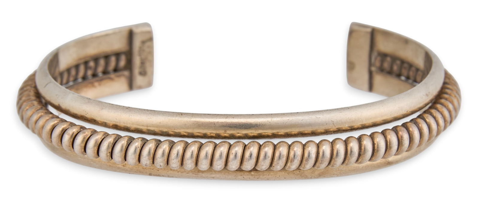 Sterling Silver Ribbed Cuff Bracelet: Sterling silver cuff bracelet with central ribbed band, marked "Sterling"Circumference: 6.5 in. Total weight: 1.035 oztProvenance: Property from the collection of a San Antonio, Texas