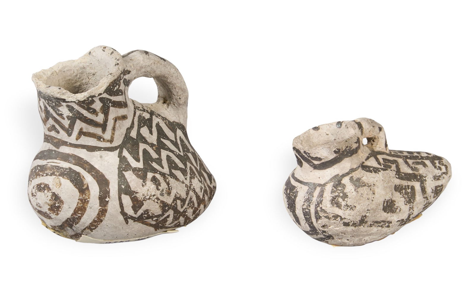 (2) Anasazi Miniature Duck Effigy Pottery Vessels, ca. 875-1130 AD: Set of two miniature Anasazi duck effigy pottery pitchers, each with geometric black-on-white designs, the larger from Mesa Verde, the smaller from Black Mesa, circa 875-1130 AD height 2.75 in. x