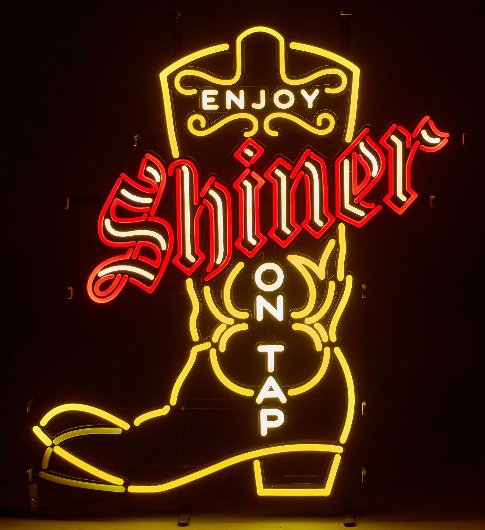 Shiner "On Tap" Neon Sign, 21st C.: Shiner Beer neon sign, with cowboy boot design, featuring red, white, and yellow stylized neon, with tapping boot effect, circa 21st centuryheight 26 in. x width 18.5 in. x depth
