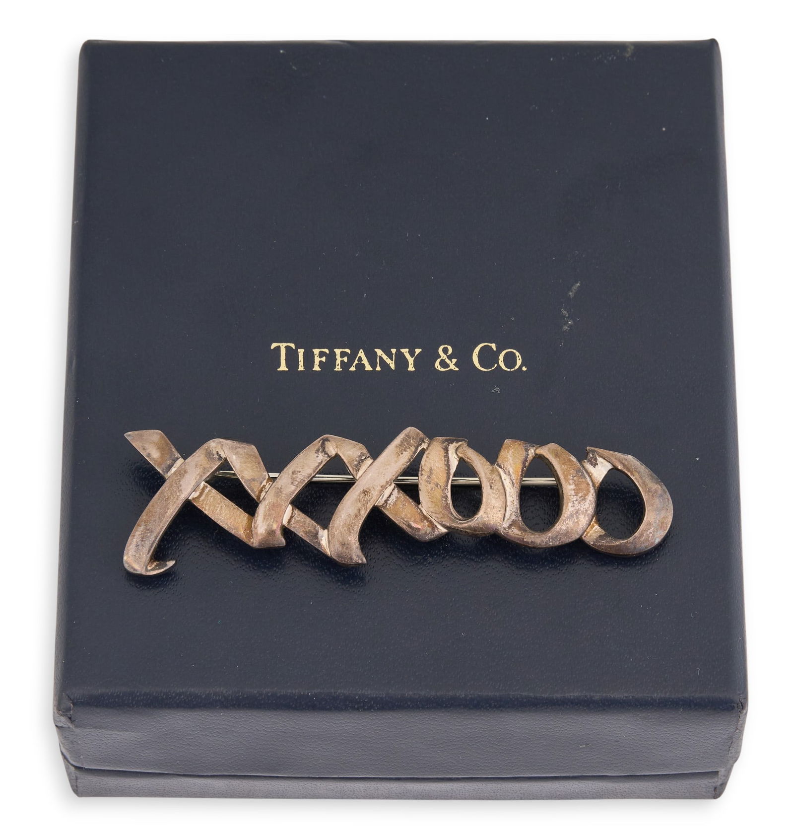 Tiffany & Co. Sterling Silver "XXXOOO" Pin: Tiffany & Co. sterling silver pin, reading "XXXOOO", marked "1983 Tiffany & Co. Sterling"Total weight: 0.295 oztProvenance: Property from a home in San Antonio,