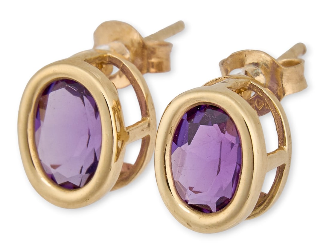 14K Amethyst Earrings: Pair of 14K yellow gold stud earrings, each set with an oval-cut amethyst in bezel-style mounts with open gallery backs, marked “14K BJC.”Total weight: 1.8 gProvenance: Property from a