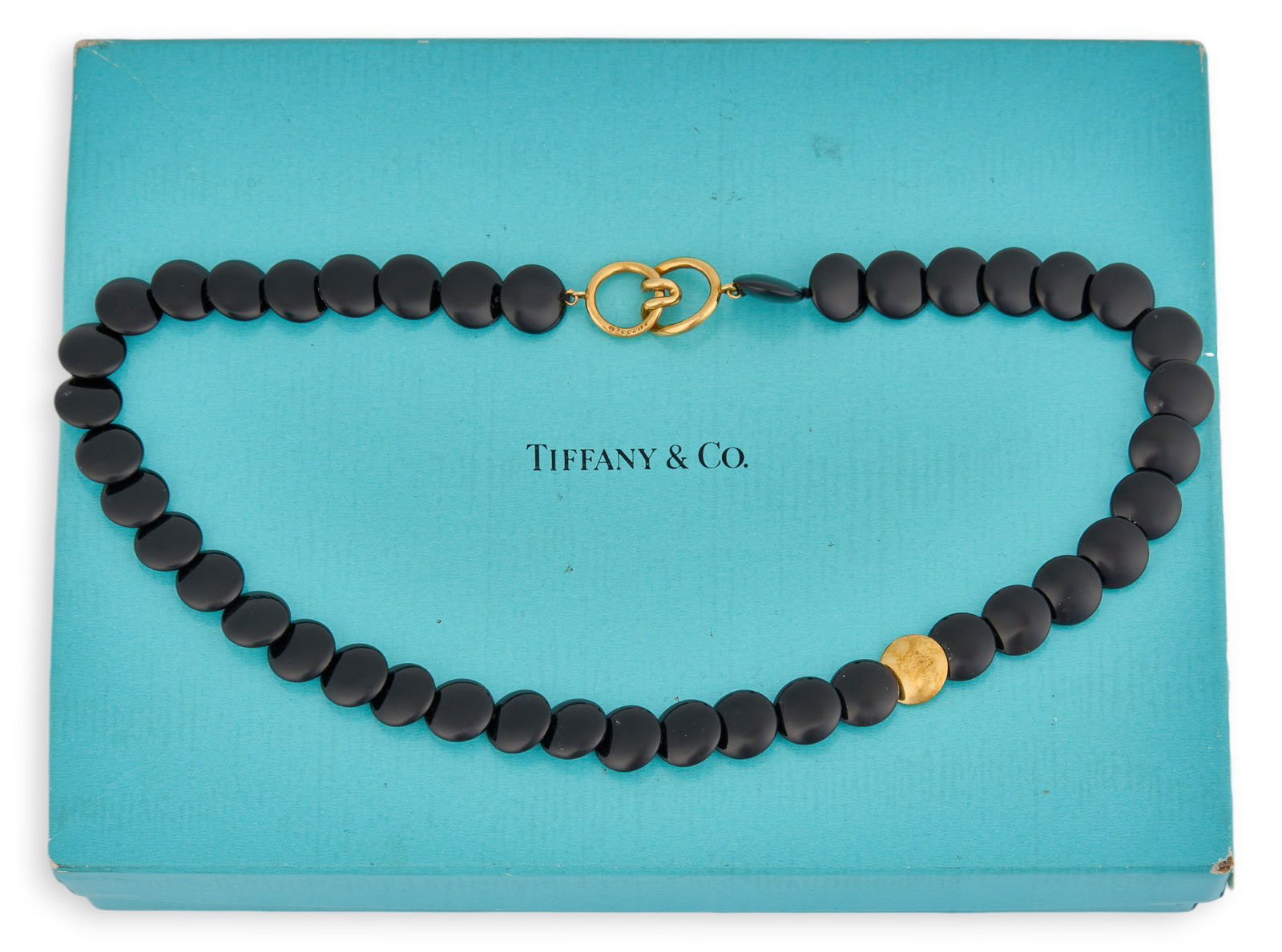 Tiffany & Co. 18K Black Beaded Necklace: Tiffany & Co. necklace with flat black beads and 18K yellow gold clasp, marked "T & Co. 18K"Length: 16 in. Total weight: 31.3 gProvenance: Property from a home in San Antonio, Texas