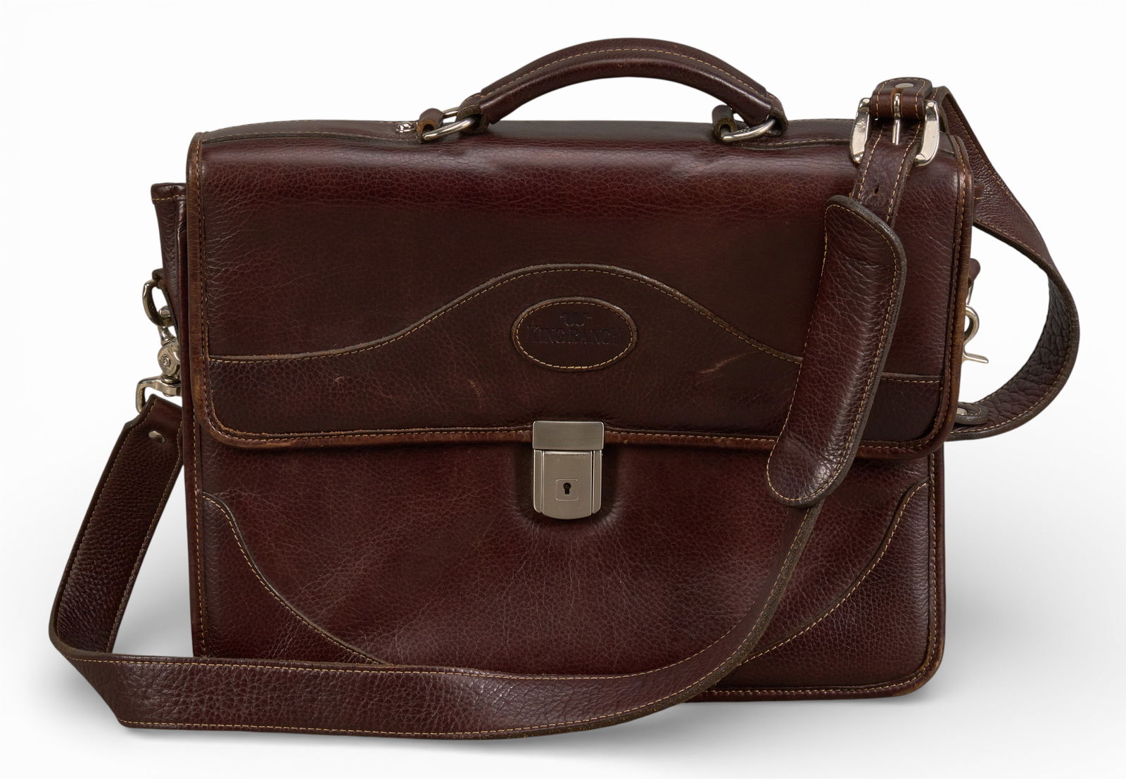 King Ranch Leather Satchel: King Ranch satchel of dark, reddish brown leather, with leather handle and strap, and silver metal hardware15 in. x 12 in. x 2 in.Provenance: Property from a home in San Antonio, TexasCondition A;