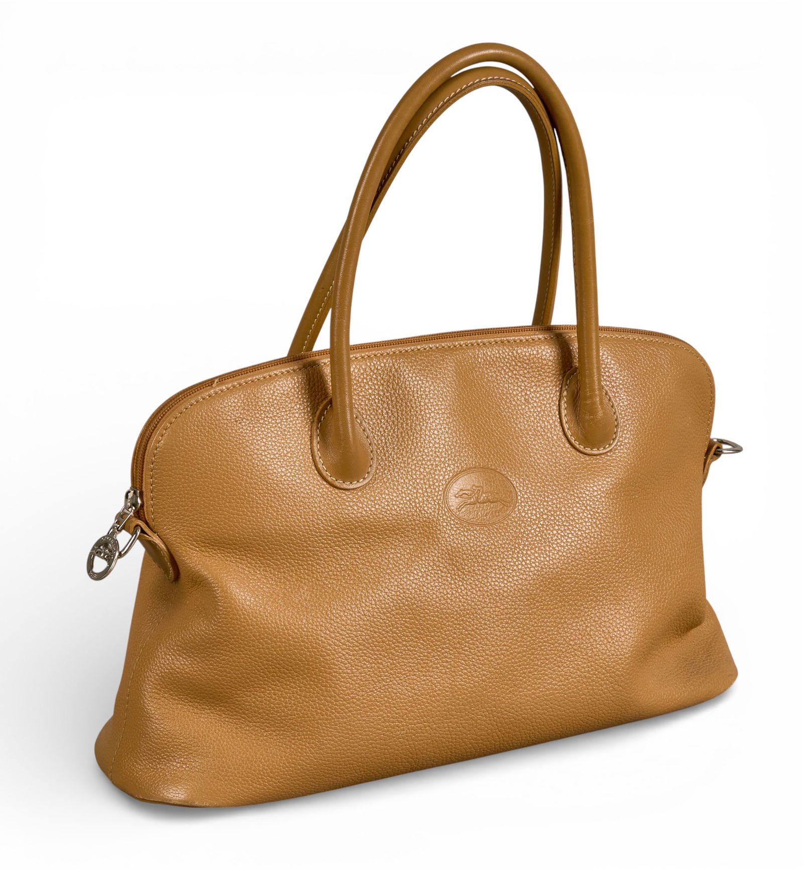 Longchamp Tan Leather Handbag: Longchamp tan leather handbag with double handles and a zip closure, includes a detachable shoulder strap and key ringProvenance: Property from a home in San Antonio, Texas