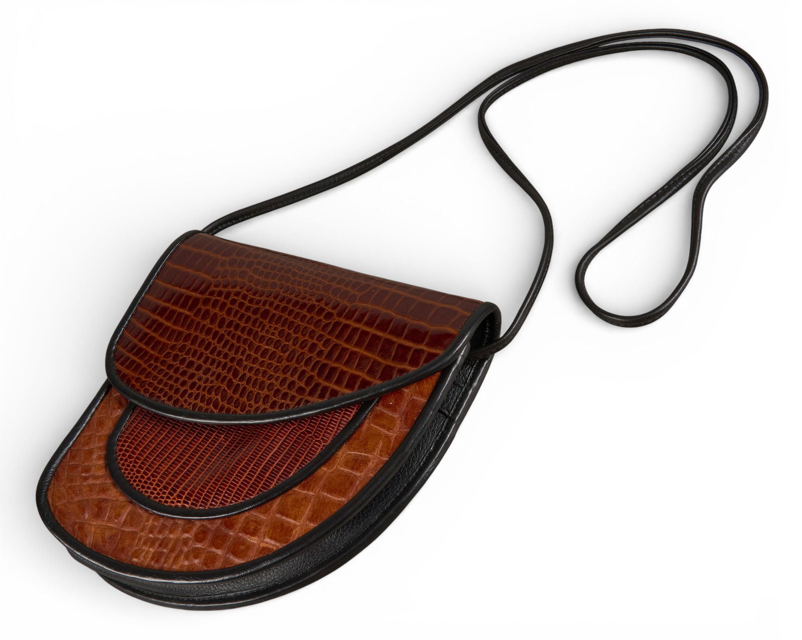 Exotic Leather Saddle Bag: Exotic leather saddle bag with black trim, shoulder strap, and layered flap closure, interior lined with pockets Provenance: Property from a home in San Antonio, Texas 