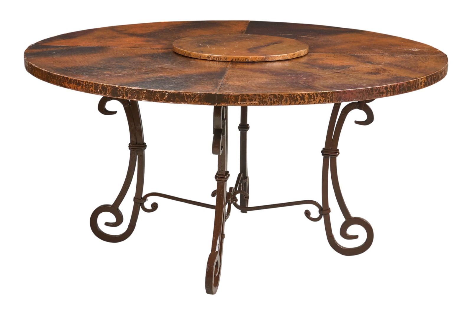Hacienda Style Copper and Iron Table: Hacienda style table with hammered copper top with lazy susan, supported on scrolled iron legsheight 31 in. x diameter 60 in. Provenance: Property from a home in San Antonio, Texas