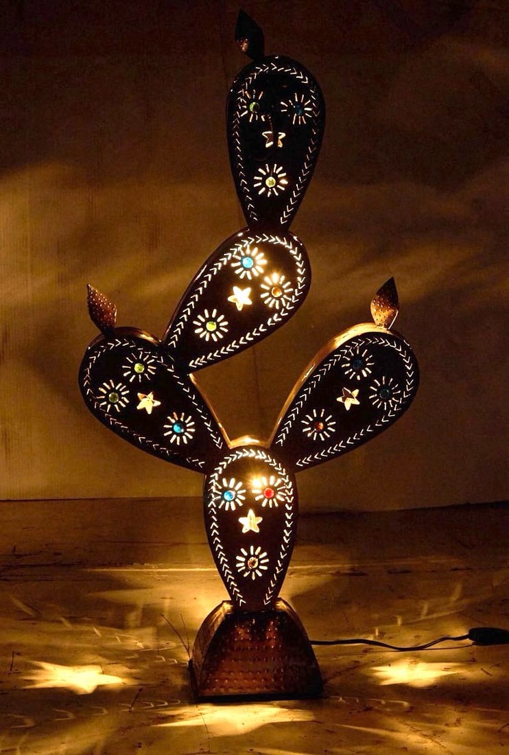 Pierced Tin Cactus Table Lamp: Pierced tin cactus-form table lamp with star and floral motifs, in working conditionheight 36 in. x width 18 in. x depth 7 in. Provenance: Property from a home in Floresville, Texas