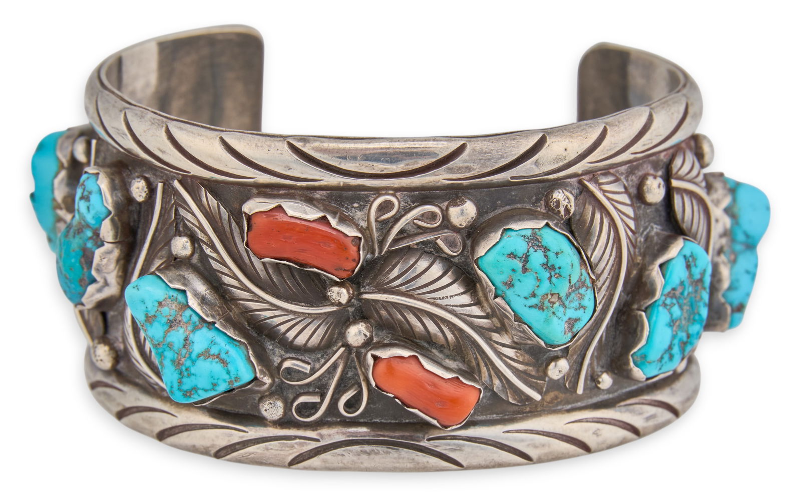 Sterling Silver Turquoise & Coral Cuff: Sterling silver cuff bracelet set with turquoise and coral stones, and feather motifs throughout, signed "S. Jon"Circumference: 7.25 in. Total weight: 3.135 oztProvenance: Property