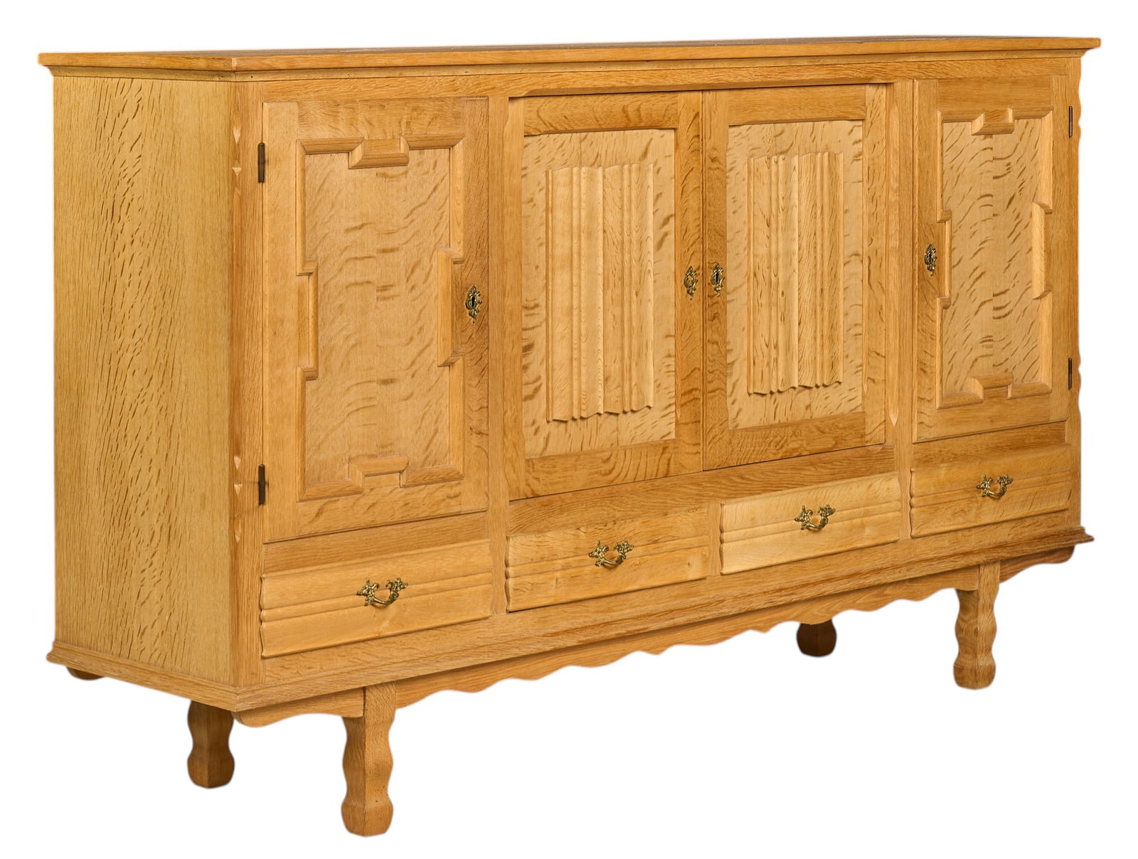 Henning Kjaernulf, Mid-Century Credenza: Henning Kjaernulf (Denmark) mid-century oak credenza with four decoratively carved doors opening to shelved interiors, above four drawers, supported on sculpted legsheight 46 in. x width 78.5