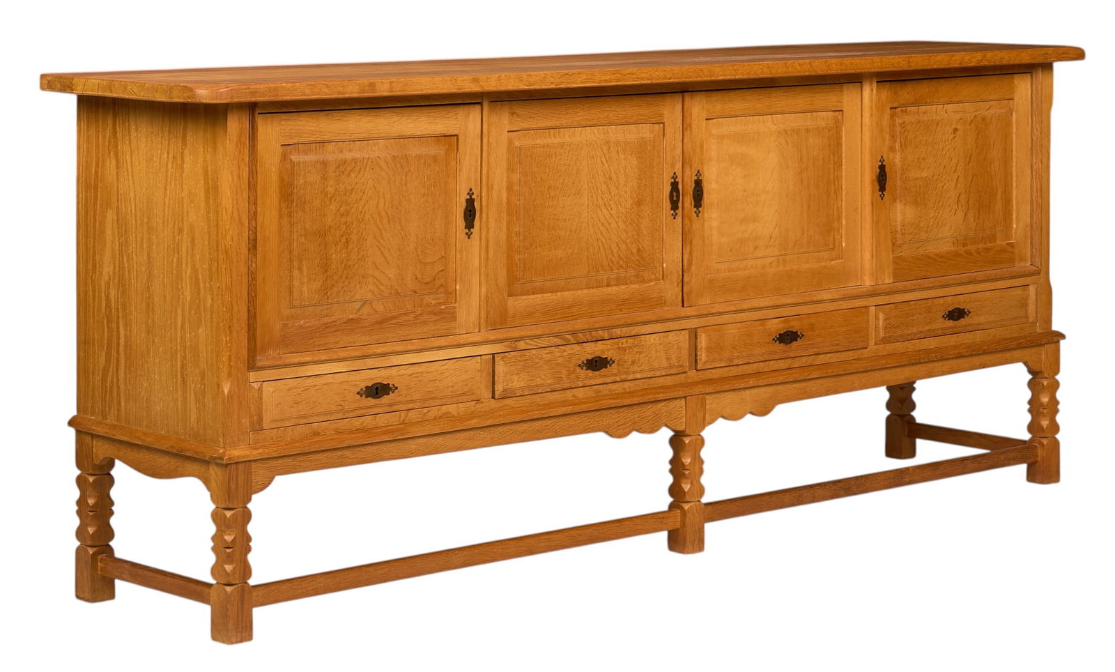 Henning Kjaernulf, Mid-Century Credenza: Henning Kjaernulf (Denmark) oak mid-century credenza with four cabinet doors, four drawers, and interior shelving, supported on sculpted block legsheight 36 in. x width 89 in. x depth 19.5