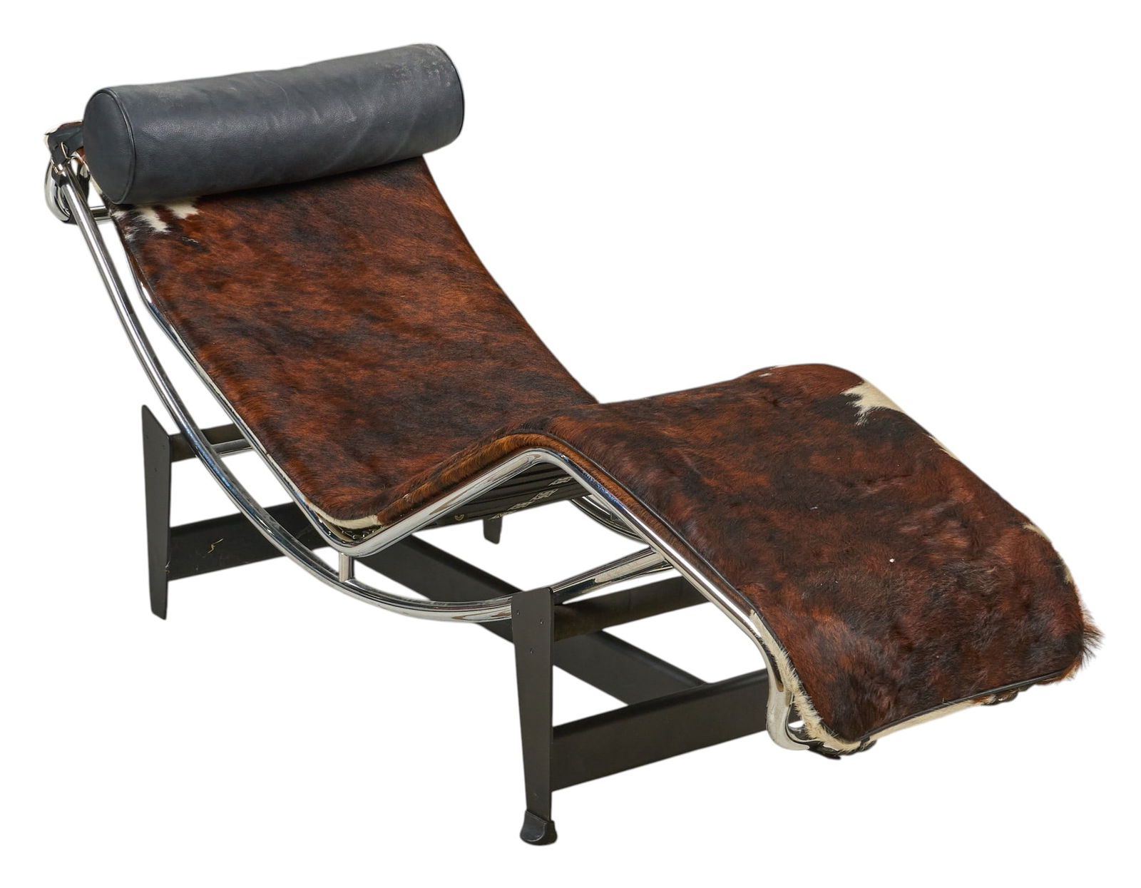 After Le Corbusier Chaise Lounge Chair: Mid-century lounge chair with chrome frame with hair on cowhide upholstery, supported on black metal base, after an original 1928 design by Charles-Édouard Jeanneret (Swit., 1887-1965), aka Le