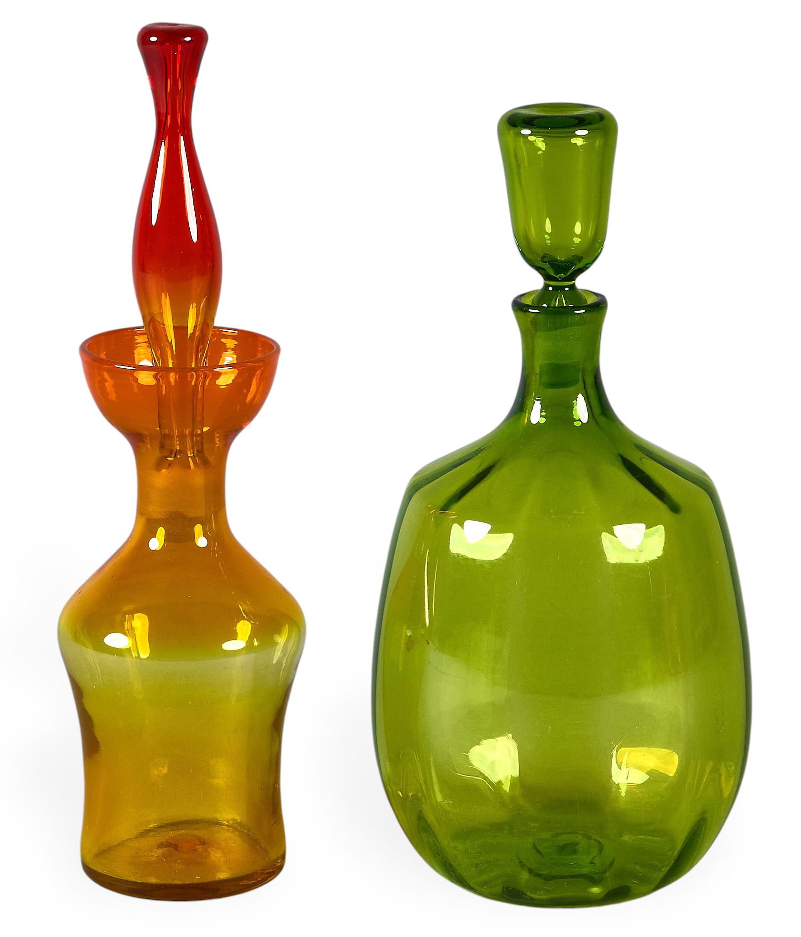 (2) Blenko Art Glass Decanters: Set of Blenko art glass decanters, one in green with stopper, and one in amber and redheight 15.5 in. x width 4.5 in. x depth 4.5 in. / largestProvenance: Property from a San Antonio, Texas