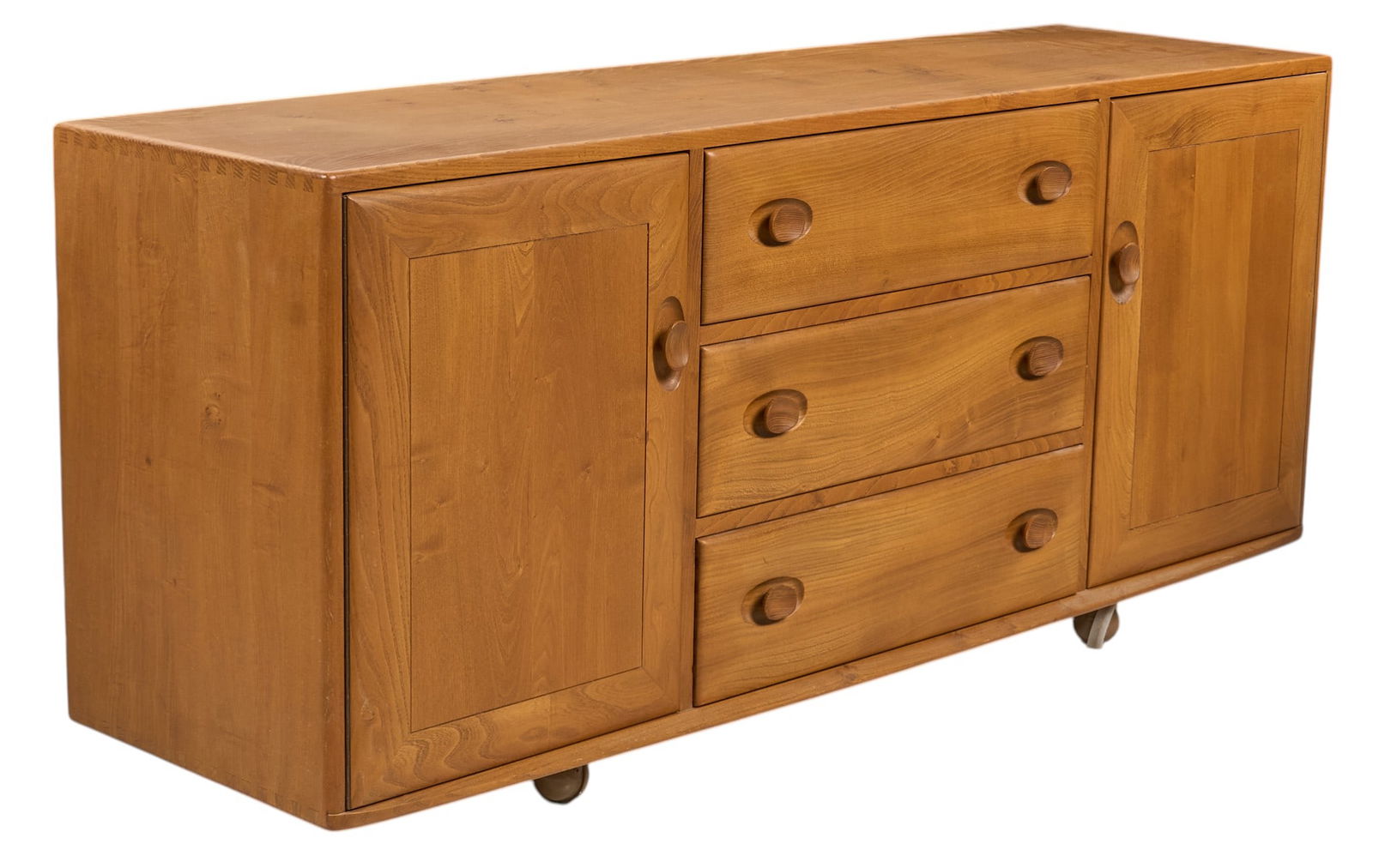 Ercol English Mid-Century Credenza: Ercol (England) mid-century elm wood credenza with three drawers, pair of cabinet doors, and interior shelves, and cutlery tray, supported on wheels, marked with Ercol sticker, circa