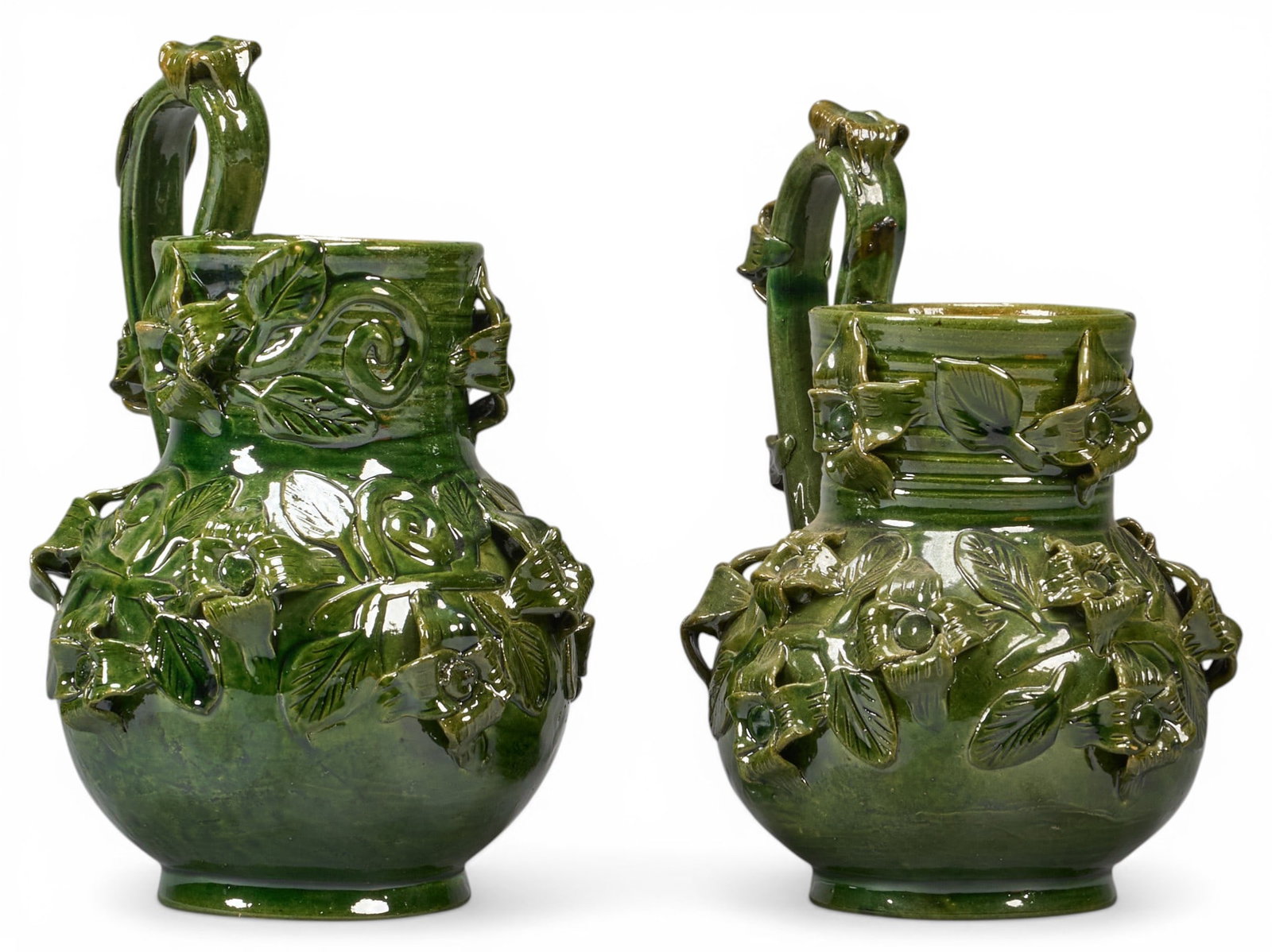 Pair of Mexican Barro Verde Carafes: Pair of vintage hand-made and glazed Michoacan carafes with botanical motifs, circa 20th centuryheight 10.5 in. x width 8 in. x depth 7 in. / eachProvenance: The Estate collection of late teacher and