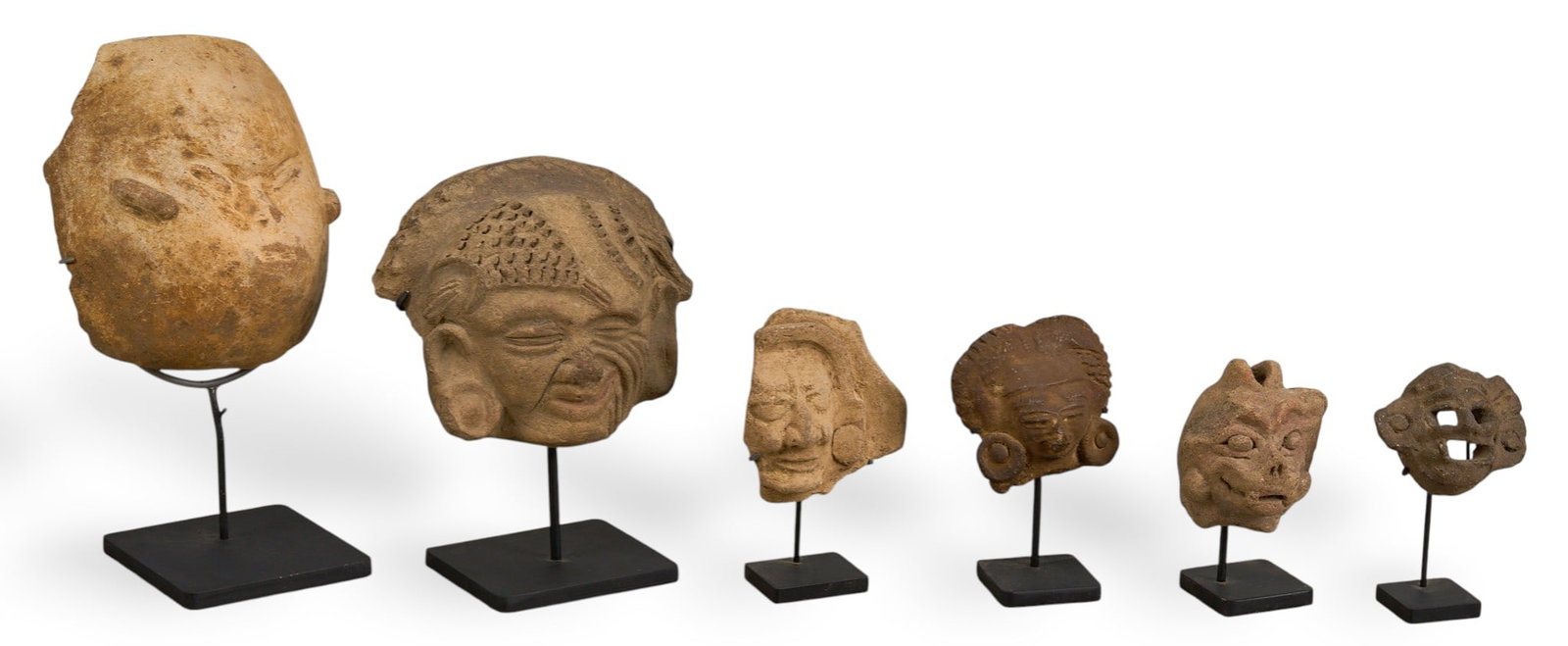 (6) Pre-Columbian Style Ceramic Fragments: Collection of six Pre-Columbian style sculptural fragments depicting figural faces, various sizes, each with custom-made metal stand, likely originally parts of larger vessels or sculptures heig