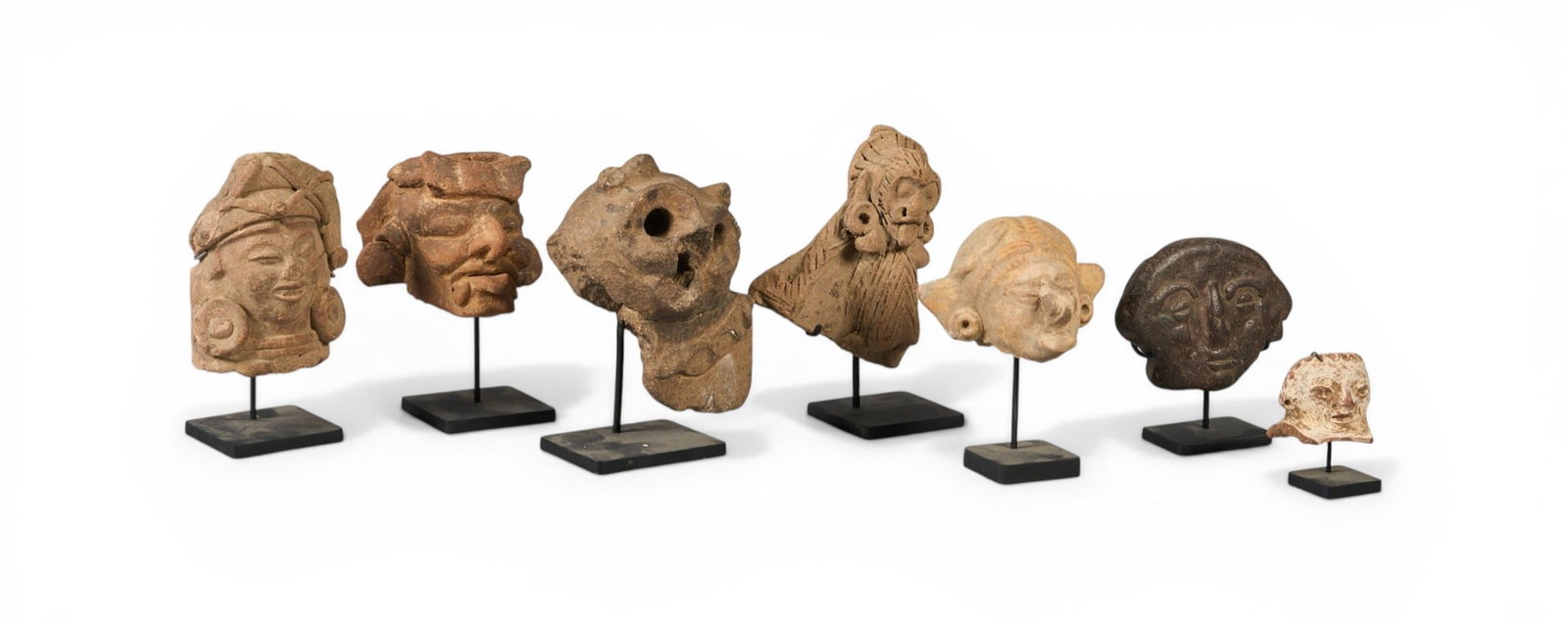 (7) Pre-Columbian Style Ceramic Fragments: Collection of seven Pre-Columbian style sculptural fragments depicting figural faces, various sizes, each with custom-made metal stand, likely originally parts of larger vessels or sculptures he