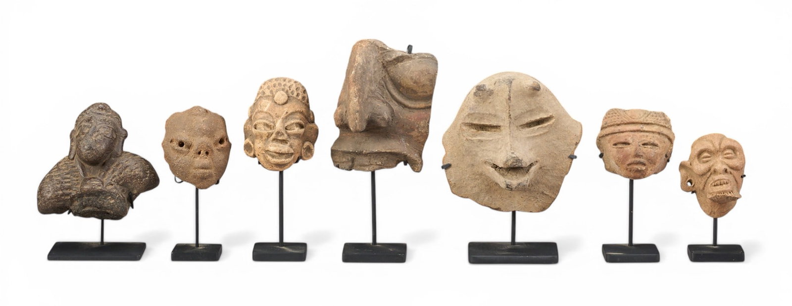 (7) Pre-Columbian Style Ceramic Fragments: Collection of seven Pre-Columbian style sculptural fragments depicting figural faces, various sizes, each with custom-made metal stand, likely originally parts of larger vessels or sculptures&nbs