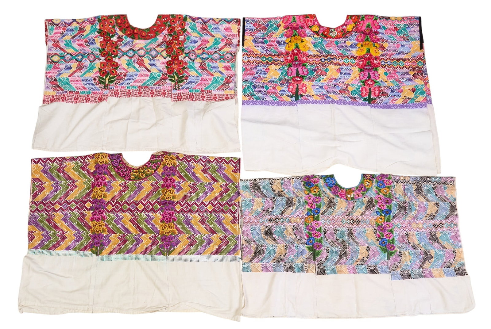 (4) Embroidered Guatemalan Huipils: Collection of four embroidered Guatemalan huipils, with floral motifs in vibrant colors height 36 in. x width 27 in. / largest Provenance: The Estate collection of late teacher and