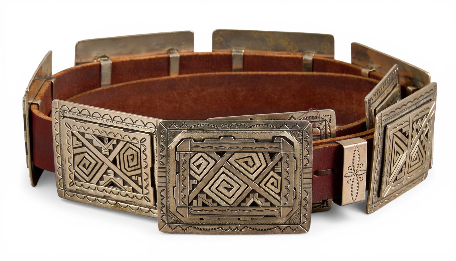 Peter Nelson, Navajo Sterling Silver Concho Belt: Peter Nelson, Navajo sterling silver concho belt, with eight conchos and buckle on brown leather belt, featuring hand-stamped details throughout, buckle signed and marked "Sterling" Length: 