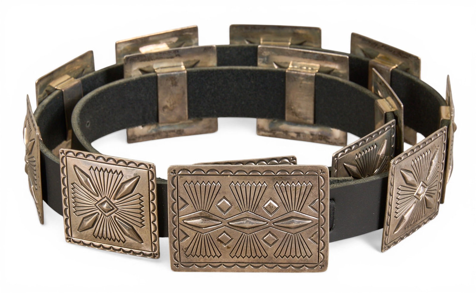 Navajo Sterling Silver Concho Belt: Navajo sterling silver concho belt, with thirteen conchos and buckle on black leather belt, with hand-stamped details throughout, buckle signed "Jennifer" Length: 46 in. Total weight: 21.305