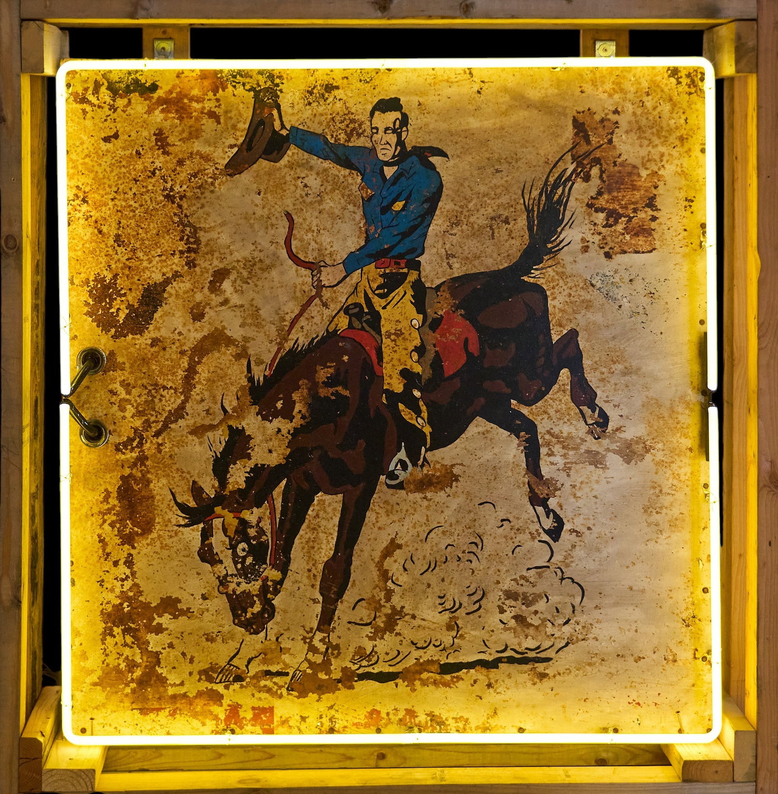 Bucking Bronco Neon Sign (Left Facing): Custom-made Western style neon sign with rustic painted metal sign depicting cowboy on bucking bronco facing left with newer neon tubing, includes custom-made shipping crate height 47 in. x width 46