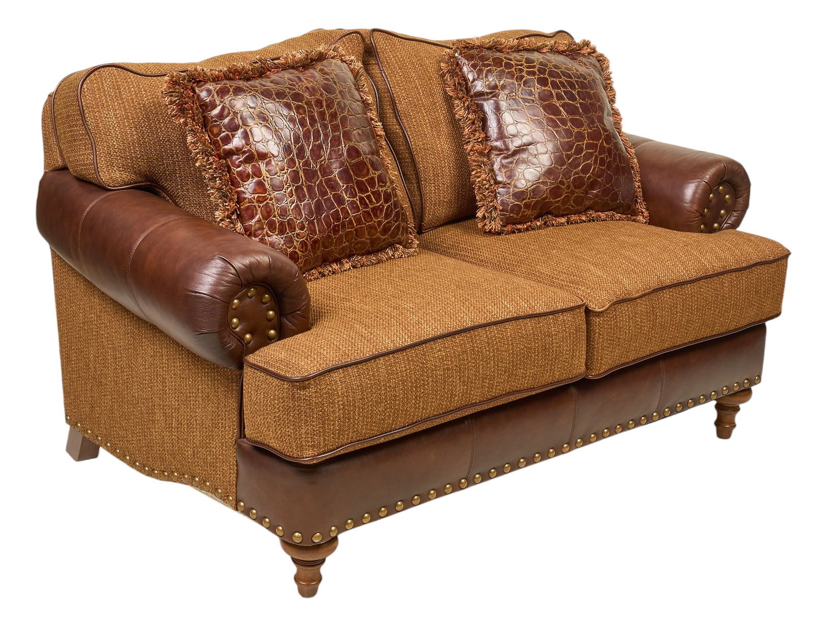 Ranch Style Sofa: Ranch style two-seat sofa with brown fabric upholstery and brown leather upholstery, with metal nail trim, embossed leather pillows, and turned legs height 33 in. x width 65 in. x depth 39 in. 