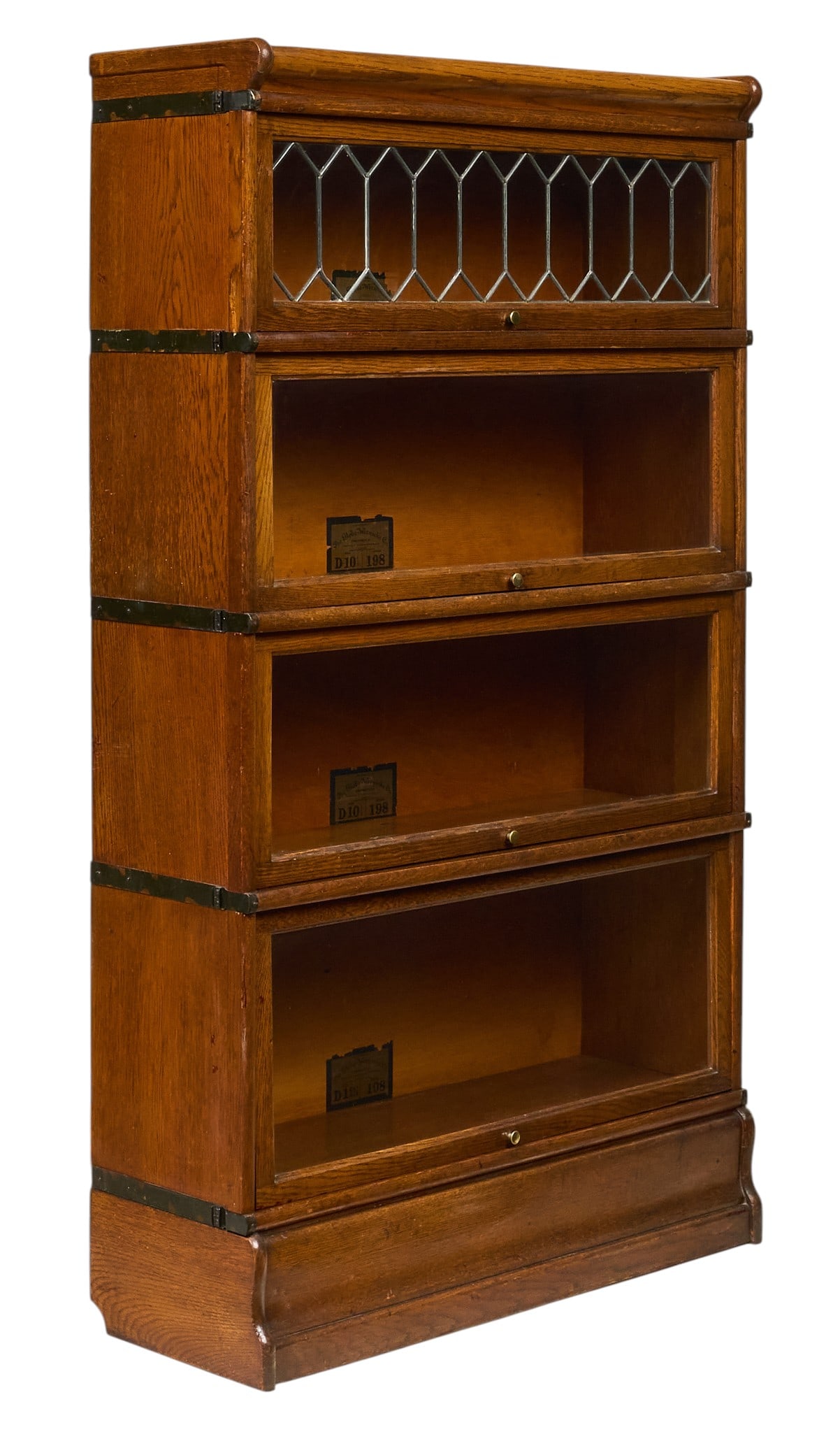 Globe-Wernicke Co. Stacking Bookcase: Globe-Wernicke Co four-section stacking bookcase, with leaded glass top section and three lower tiers with glass-fronted doors, supported on a wooden base, marked with label height 60