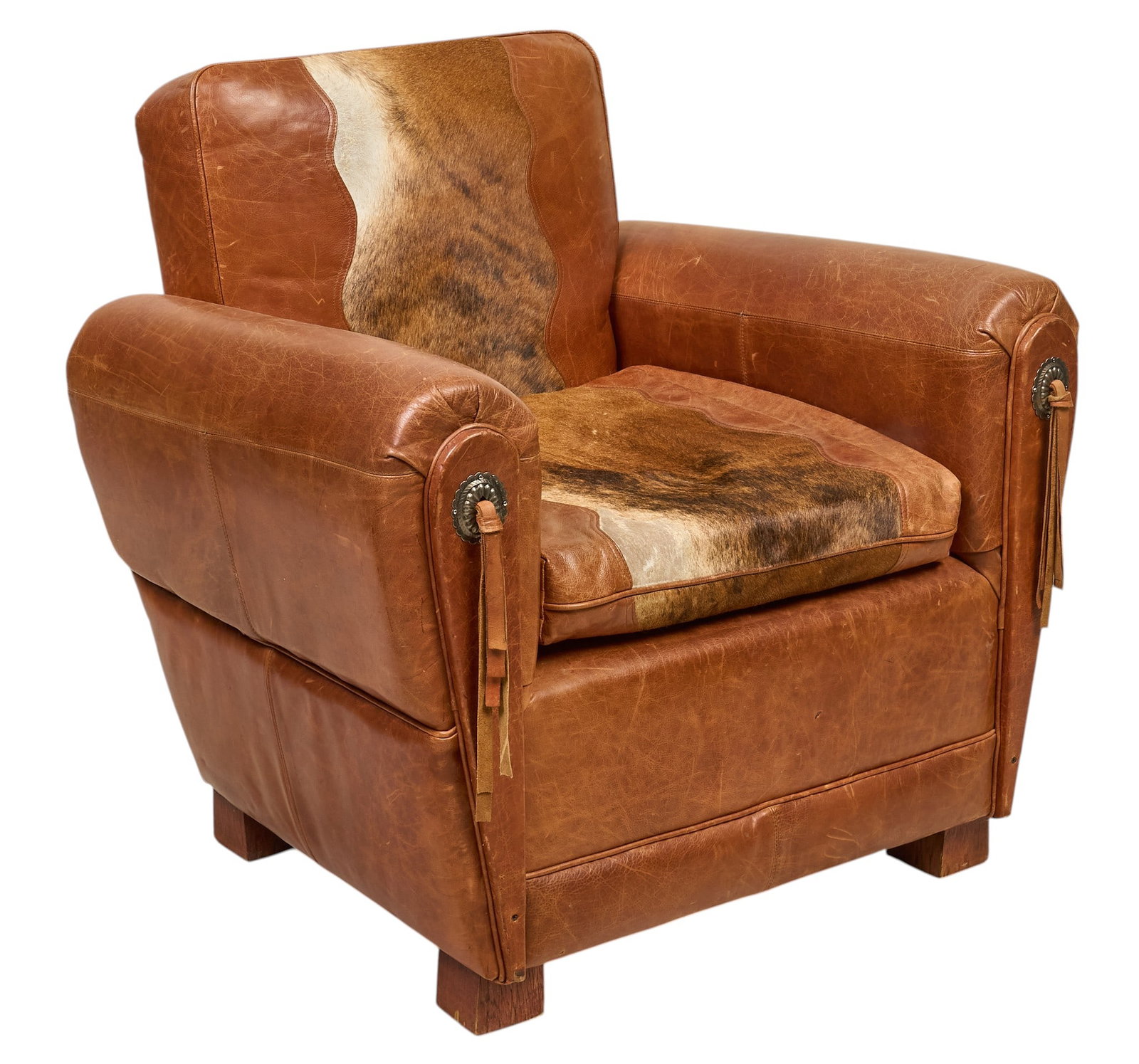Western Armchair: Western style leather armchair with hair on hide decoration, and metal concho accents height 37 in. x width 38 in. x depth 33 in. Provenance: Property from a home in San Antonio, Texas 