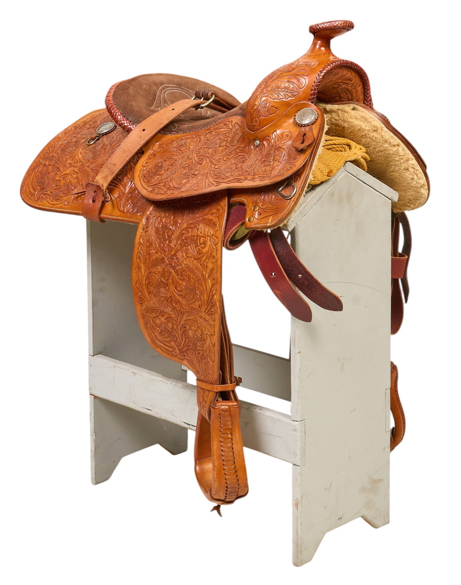Ornate Western Parade Saddle: Decoratively hand-tooled Western parade saddle with decorative silver conchos, stamped "GS", stand not included height 37.5 in. x width 32 in. x depth 23 in. Provenance: Property