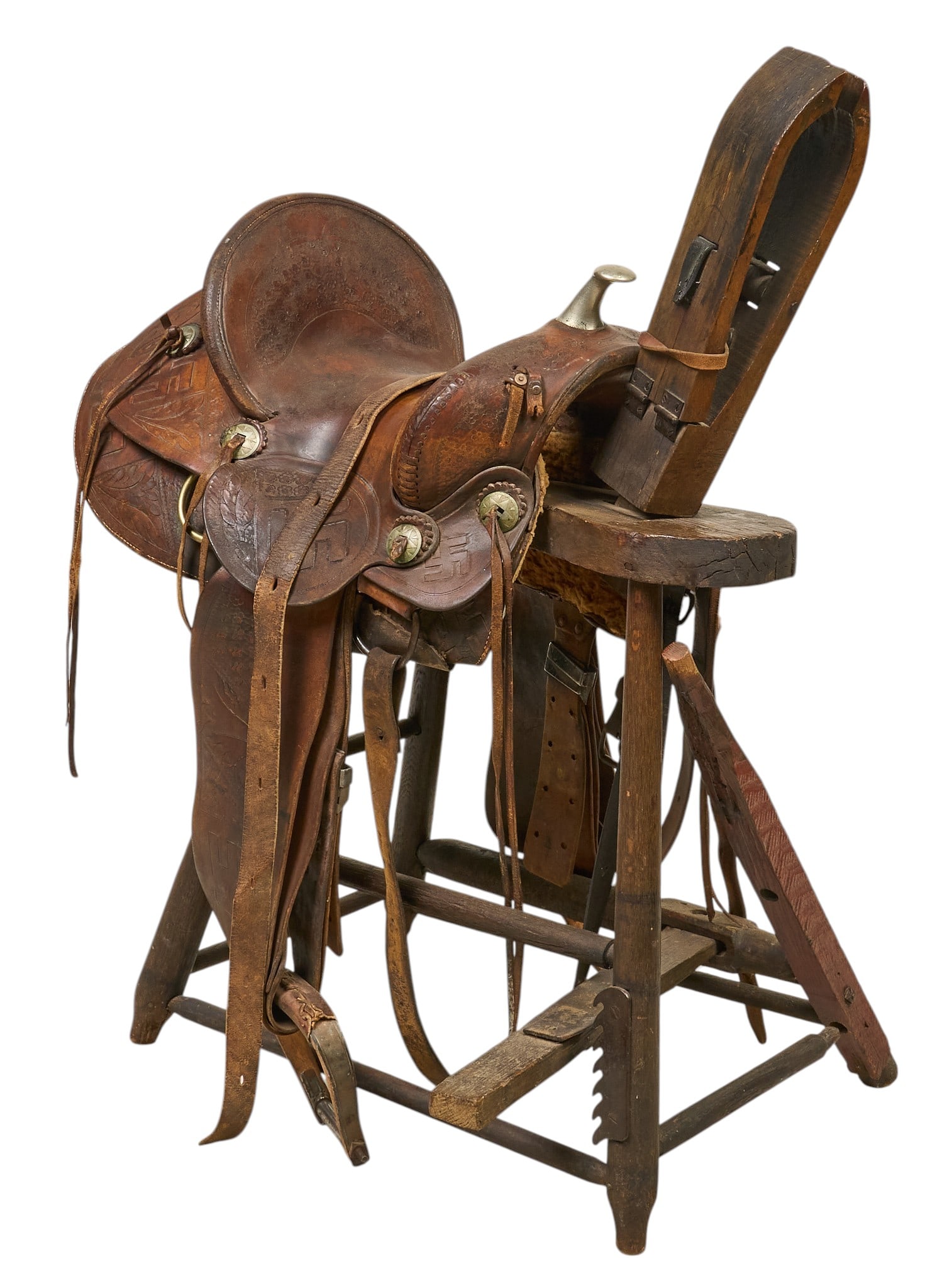 Vintage Western Saddle and Stand: Vintage Western leather riding saddle with metal pommel and conchos, circa early 20th century, includes wooden stand height 43 in. x width 18 in. x depth 29 in. Provenance: Property from the Estate of
